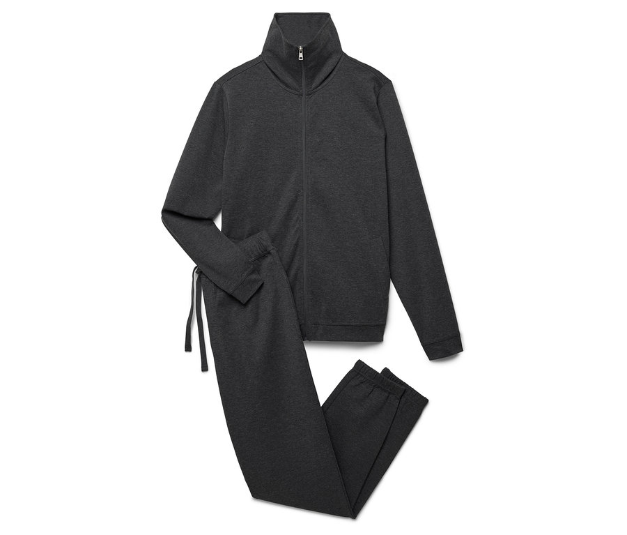 Egy szürke tréningruha cipzáras kabáttal és nadrággal egy fehér háttéren.