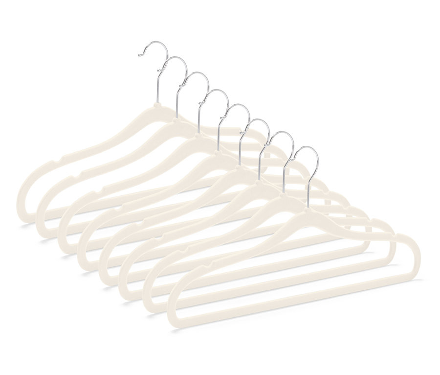 Hét bézs színű, bársony bevonatú ruhaakasztó krómozott akasztóval, átlósan elrendezve a jobb alsó sarokban.