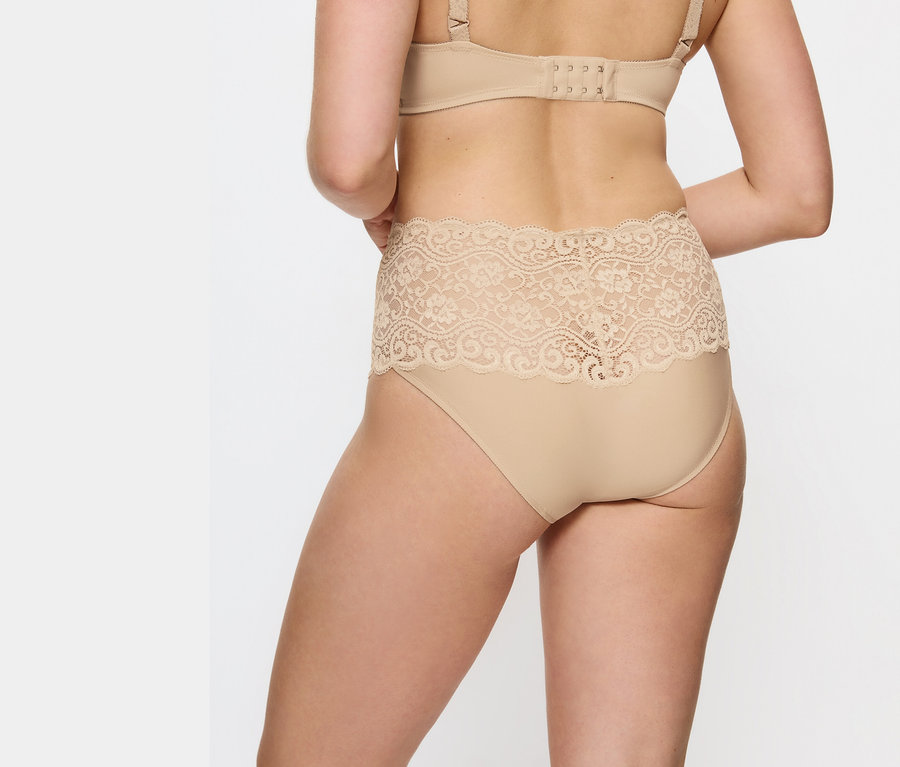 Hátulnézet egy bézs színű, csipkés derekú bugyit és melltartót viselő nőről.
