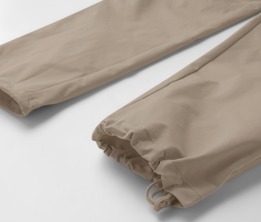 Egy bézs színű, 2 az 1-ben funkcionális nadrág részlete.