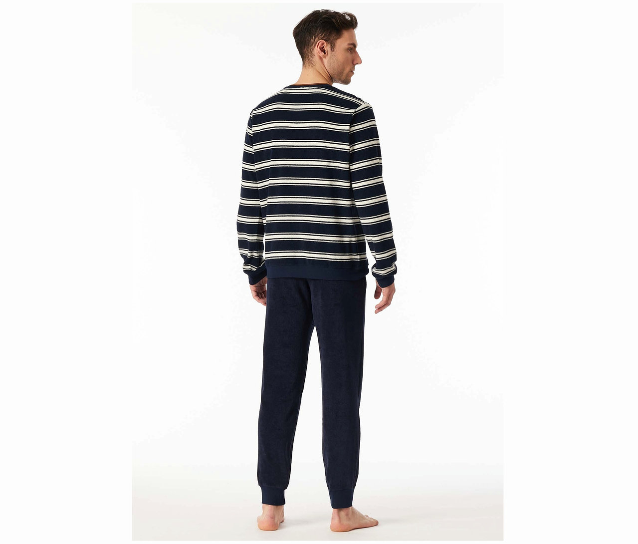 Egy férfi hátulról látható, csíkos felsőt és sötétkék nadrágot visel.