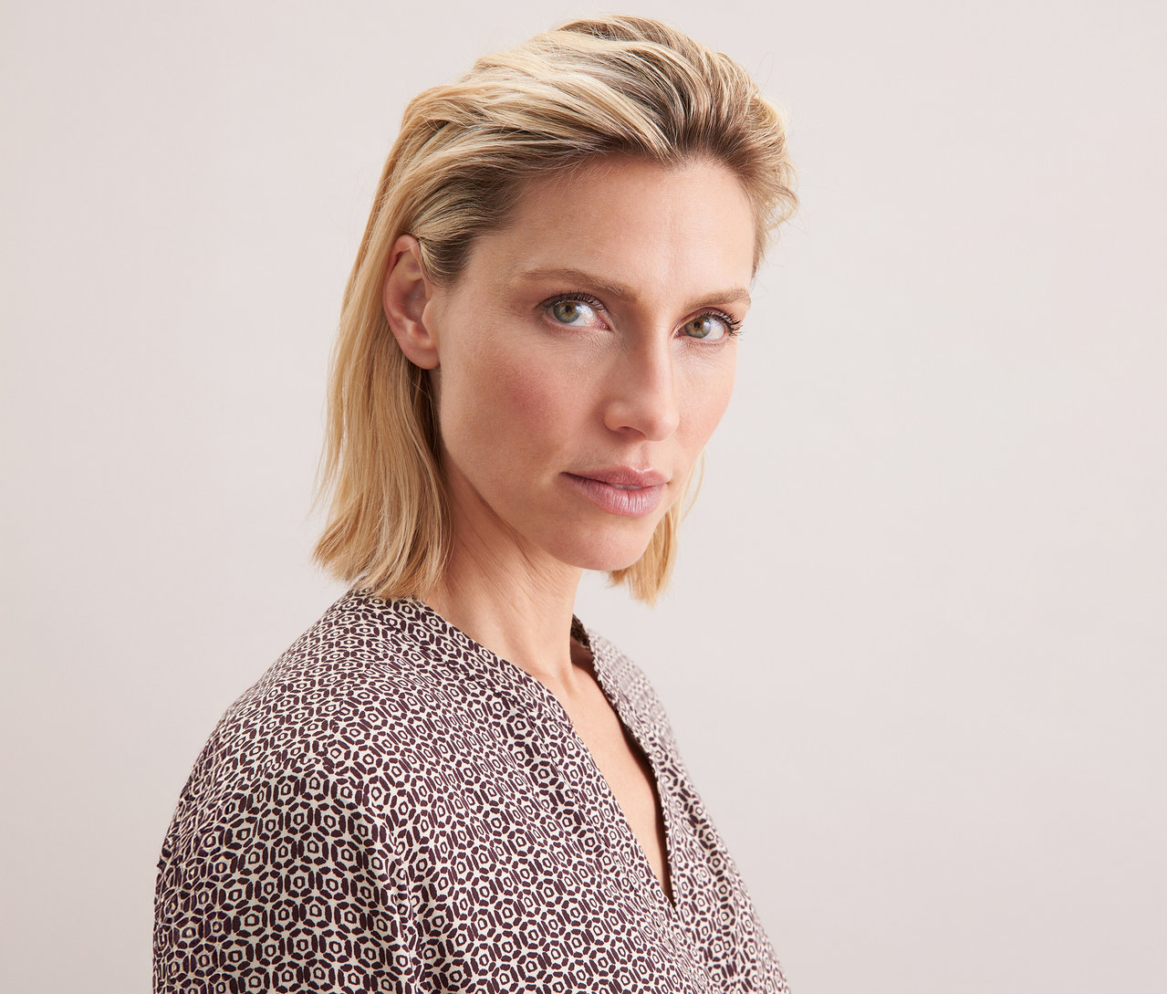 Egy szőke nő portréja ekrü-bordó mintás Seidensticker viszkóz tunikában.