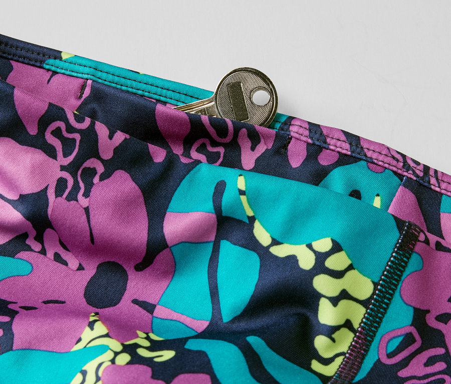 Egy 3/4-es sportnadrág részlete mintával és egy kulccsal a zsebében.