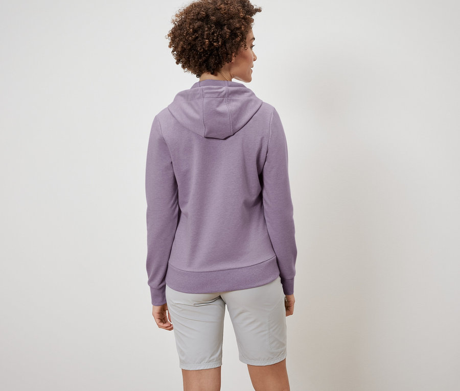 Hátulról látható egy göndör hajú nő szabadidőfelsőben és rövidnadrágban.