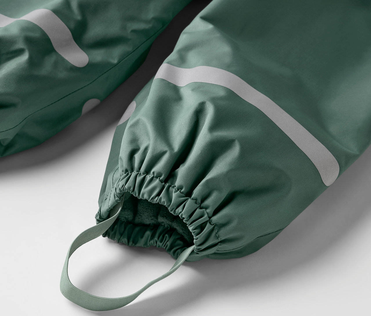 Egy zöld gyerek termo esőnadrág részlete.