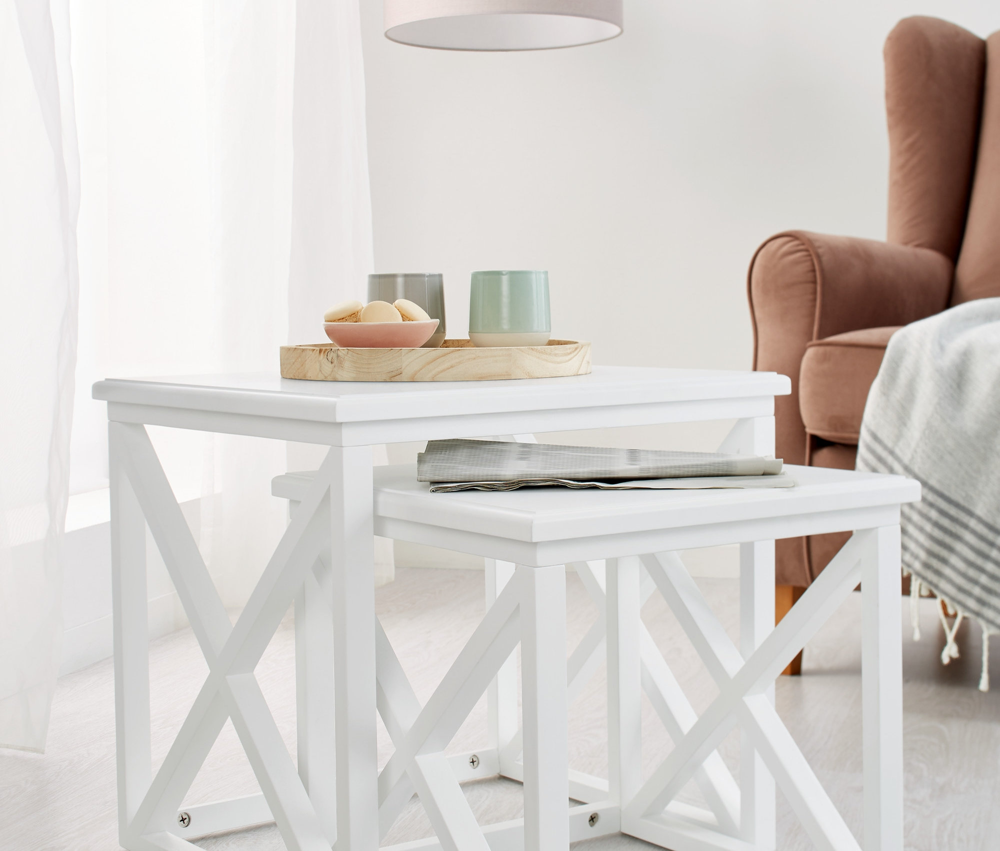 Két fehér dohányzóasztal szettben, az egyik a másik alatt.