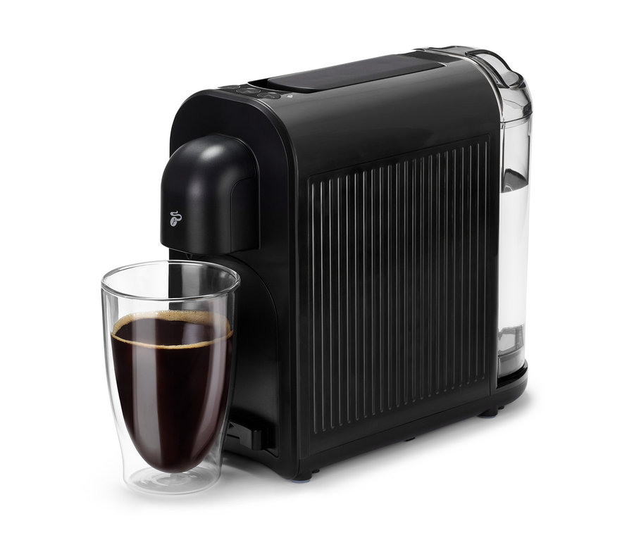 Egy fekete Cafissimo now black kávéfőző egy pohár kávé mellett.