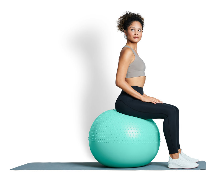 Nő ül egy fitneszlabdán.