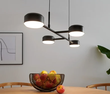Egy 4 ágú LED-es függőlámpa lóg egy gyümölcsökkel teli asztal fölött.