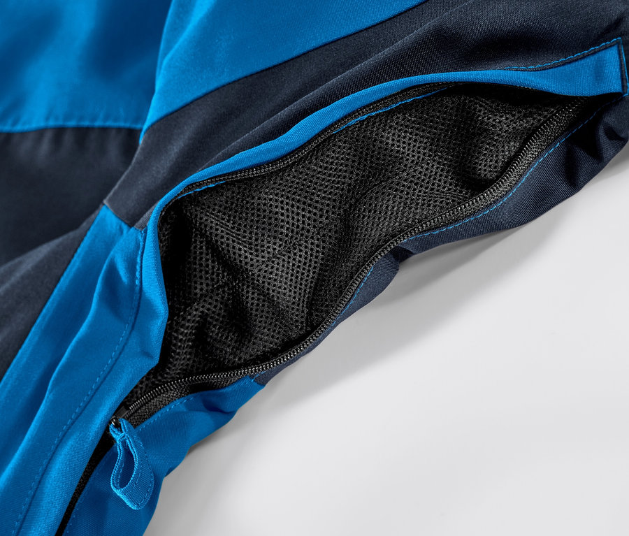 Kék síkabát részlete nyitott, cipzáras zsebbel.