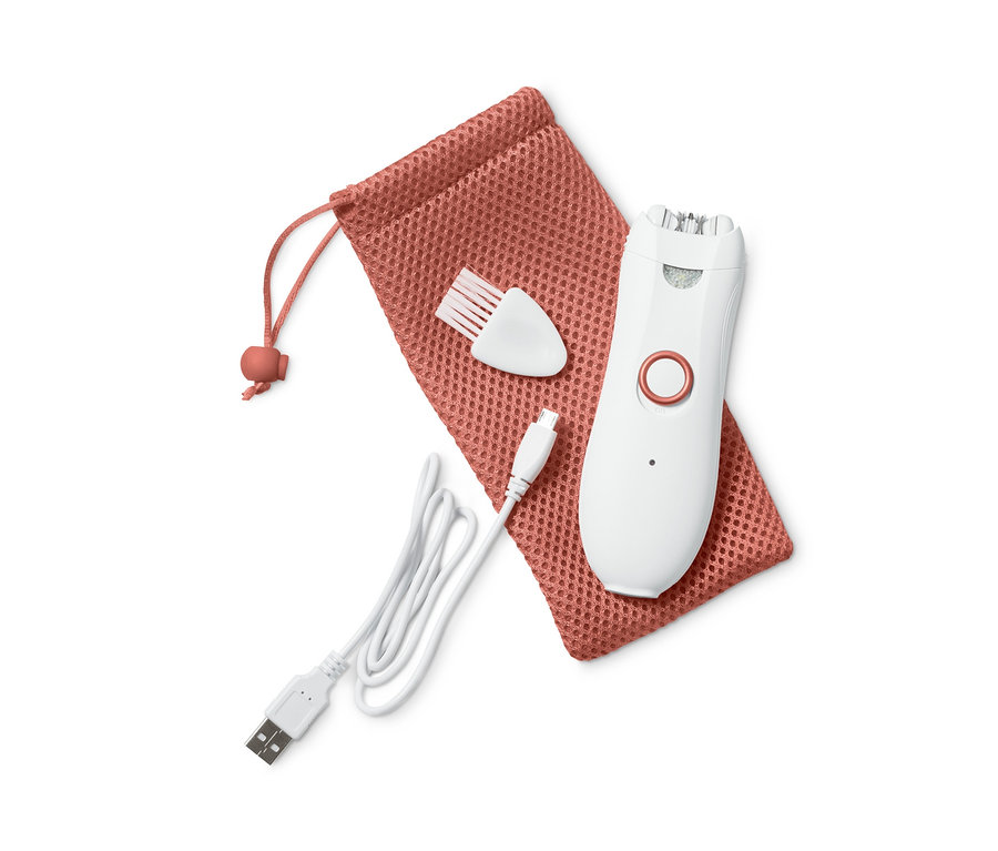 Egy fehér arcepilátor egy narancssárga húzózsinóros tasakon fekszik, mellette egy fehér kefe és egy töltőkábel.