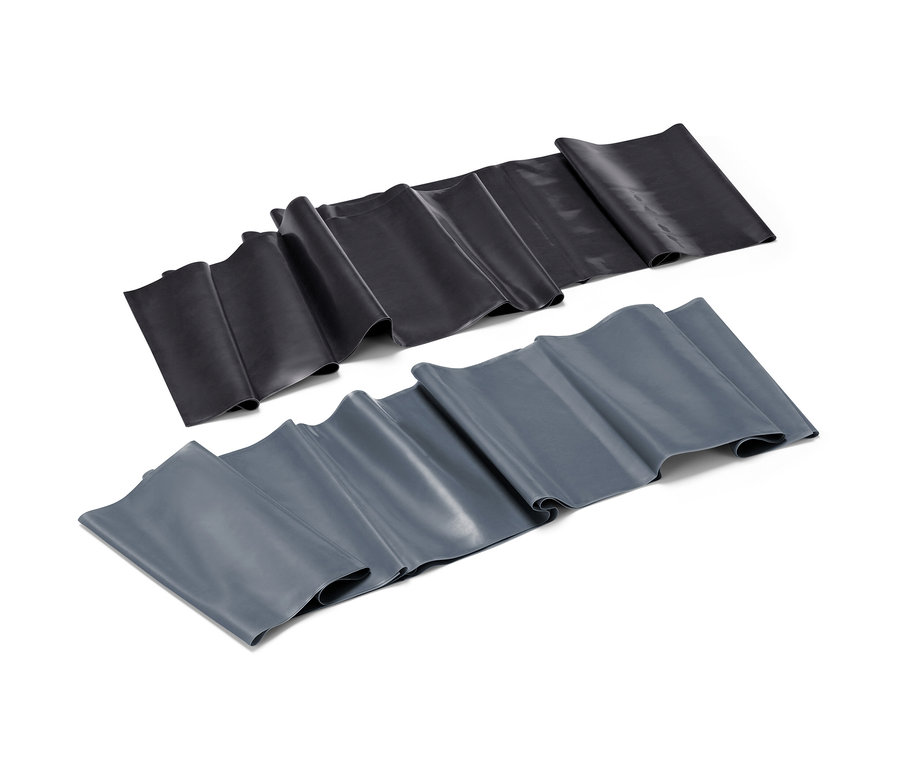 Két fitneszszalag, egy fekete és egy szürke, egymás mellett fekszik egy fehér háttéren.