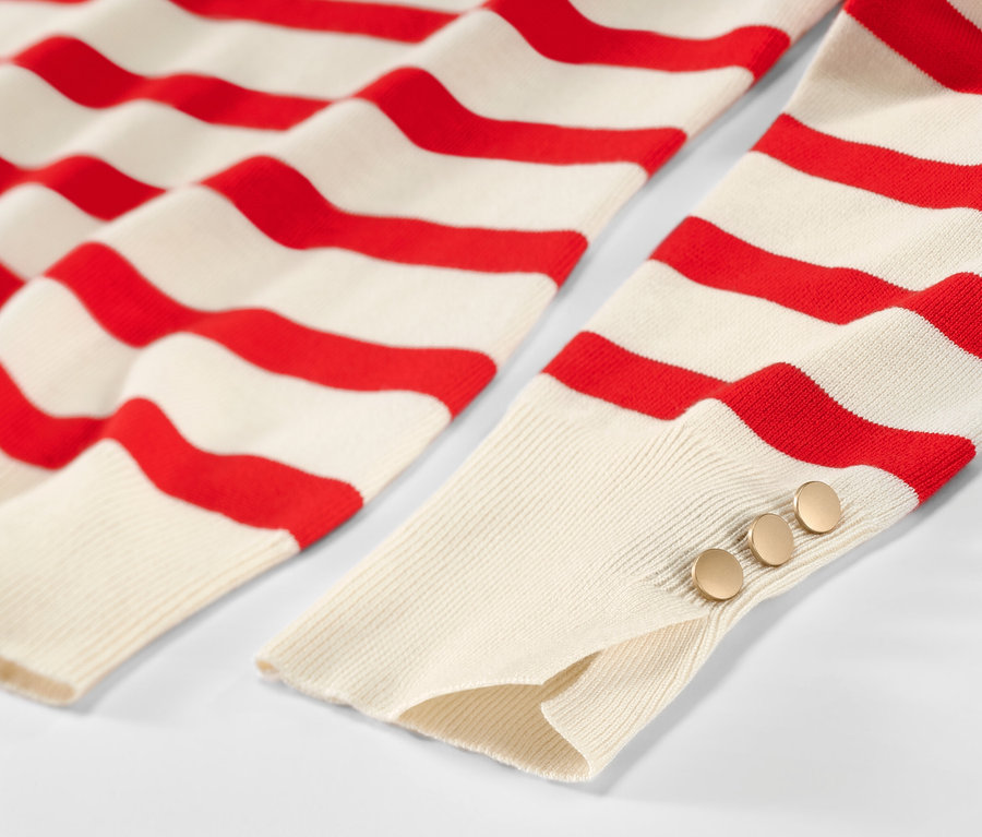 Egy piros csíkos, finomkötésű női pulóver részlete.