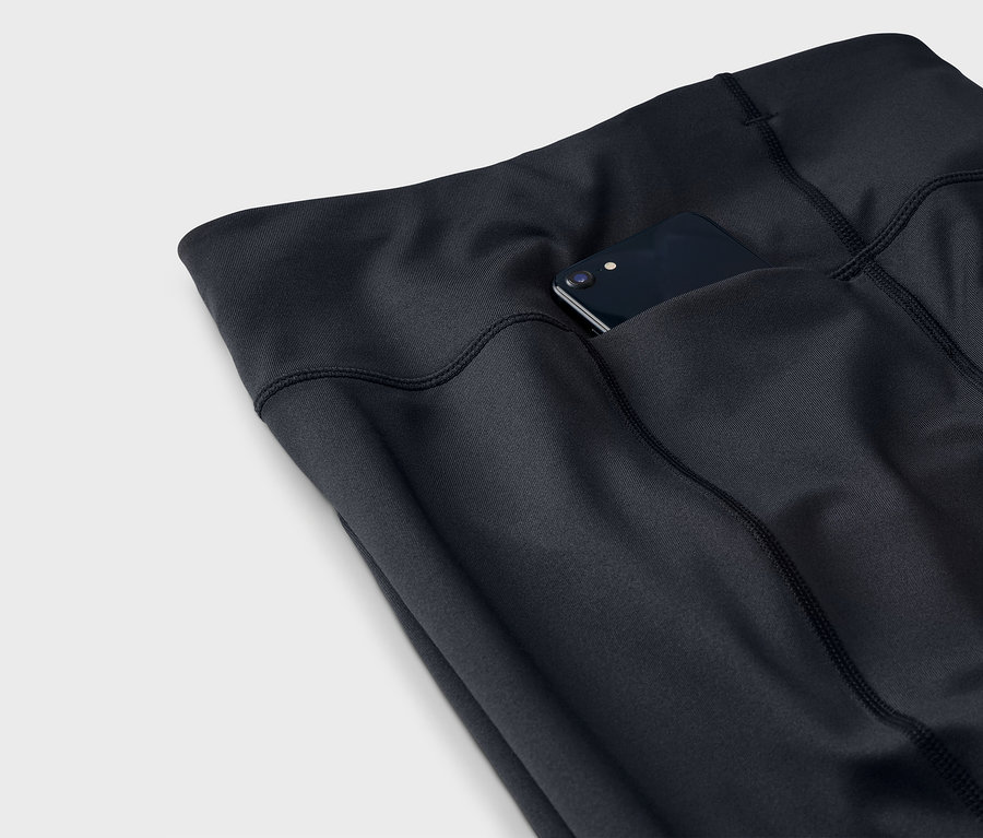 Egy fekete leggings részlete, egy okostelefonnal a zsebében.
