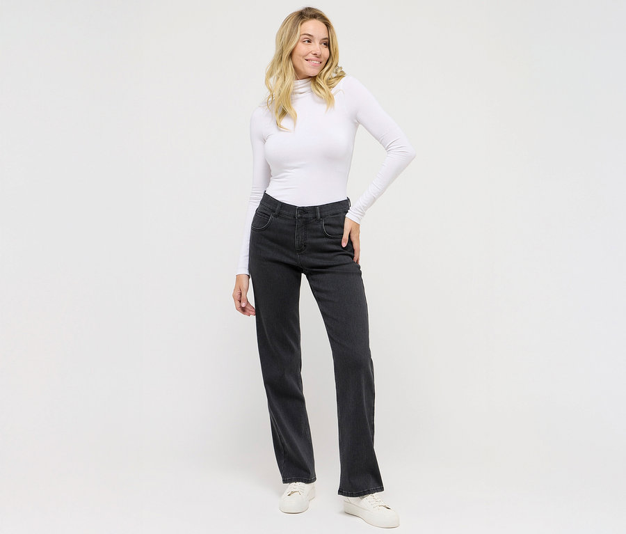 Nő pózol sötétszürke Angels denim »Lara« straight fit farmernadrágban és fehér felsőben.