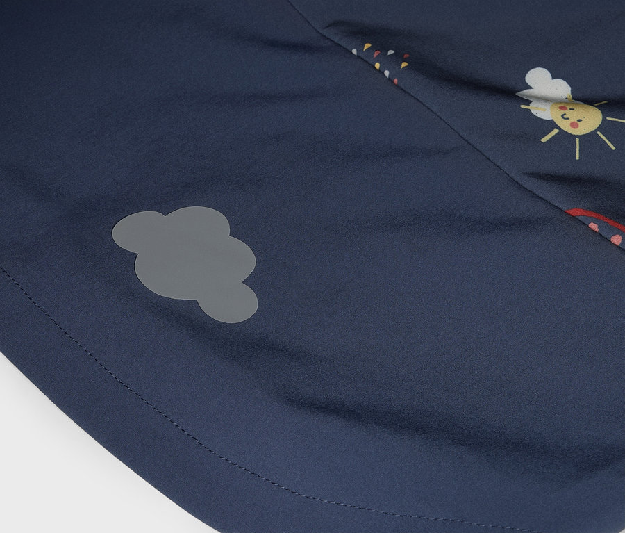 Egy sötétkék szövet közeli képe szürke felhőfolttal és egy nap-arc nyomattal.