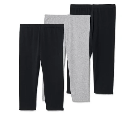 Három leggings, kettő fekete és egy szürke, egymás mellett fekszenek.
