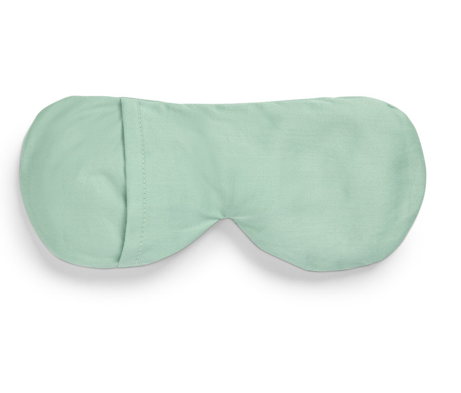 Világoszöld alvómaszk fekszik egy fehér háttéren.