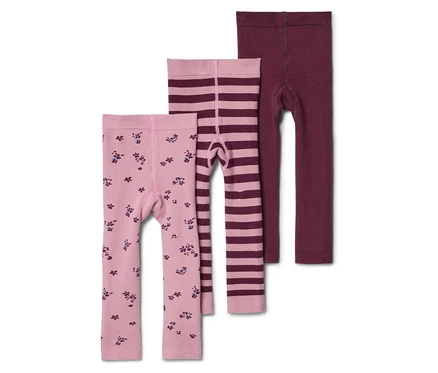 Három gyermek leggings fekszik egymáson: egy világos rózsaszín virágmintás, egy világos rózsaszín csíkos és egy bordó.