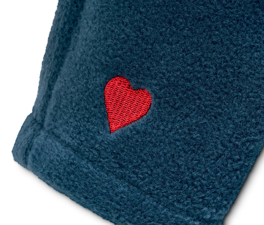 Egy sötétkék, újrahasznosított anyagból készült polár felső részlete, piros szívvel.