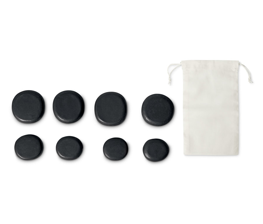 Lávakő szett masszázshoz, 8 darabos: Nyolc fekete, kerek kő és egy fehér vászonzsák.