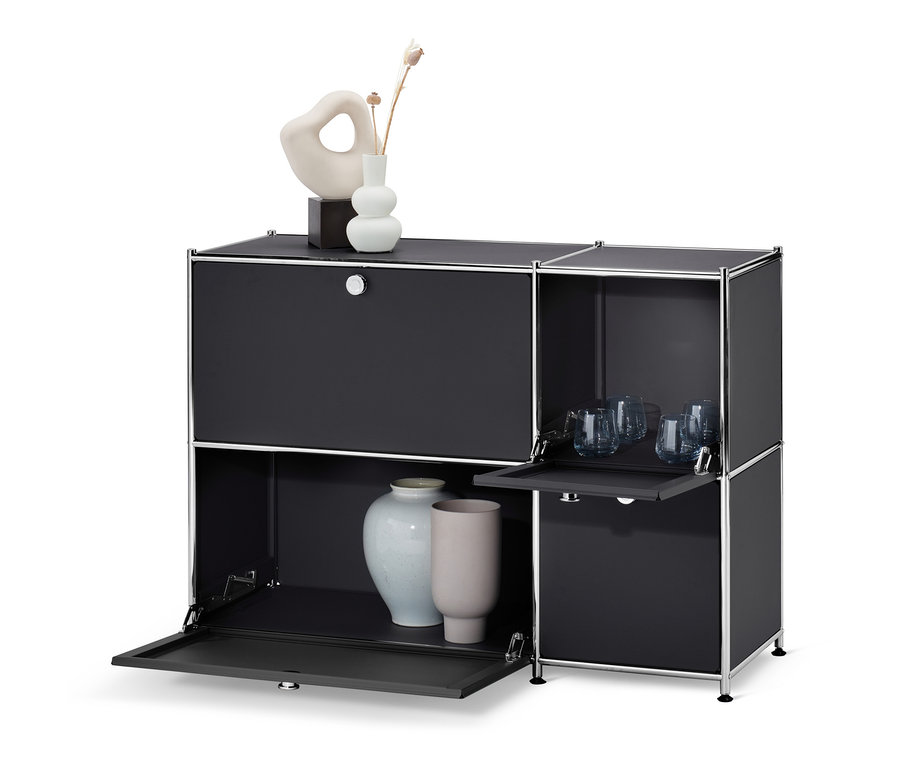 Fekete »CN3« komód 4 lenyitható ajtóval, vázákkal és poharakkal.