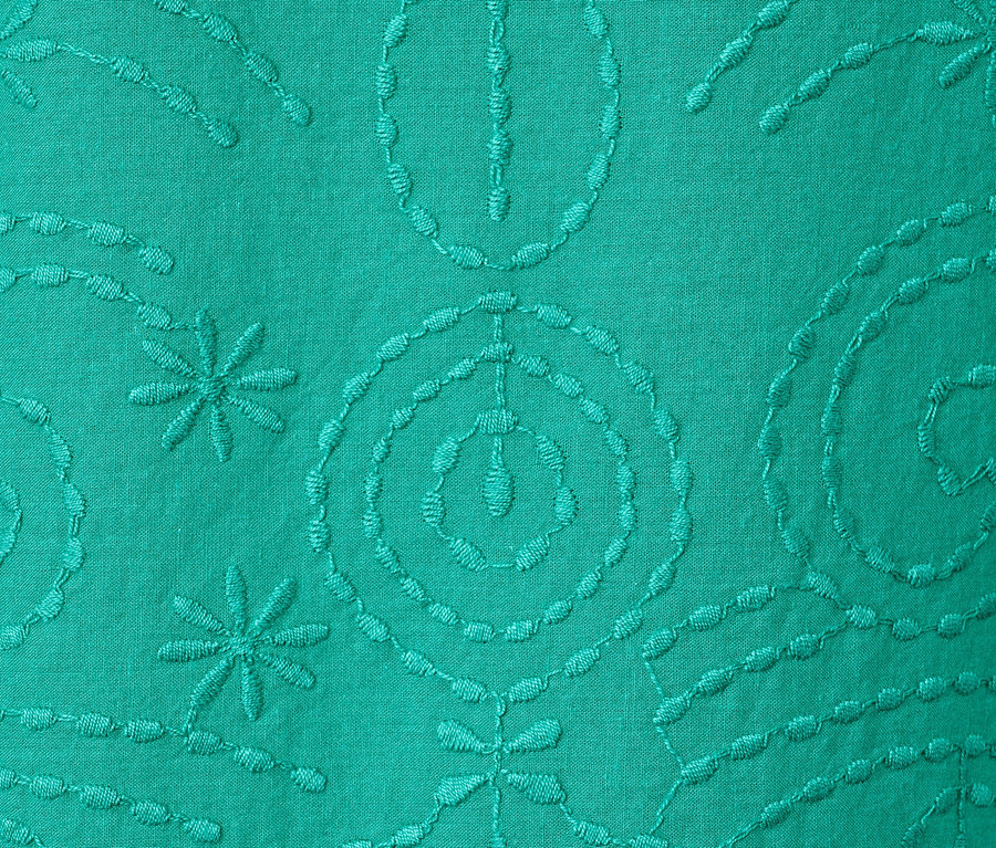 Egy zöld, hímzett női blúz részlete.