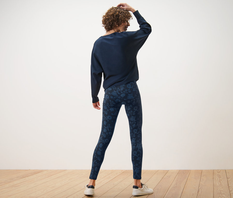 Hátulról látható nő kék, mintás leggingsben.