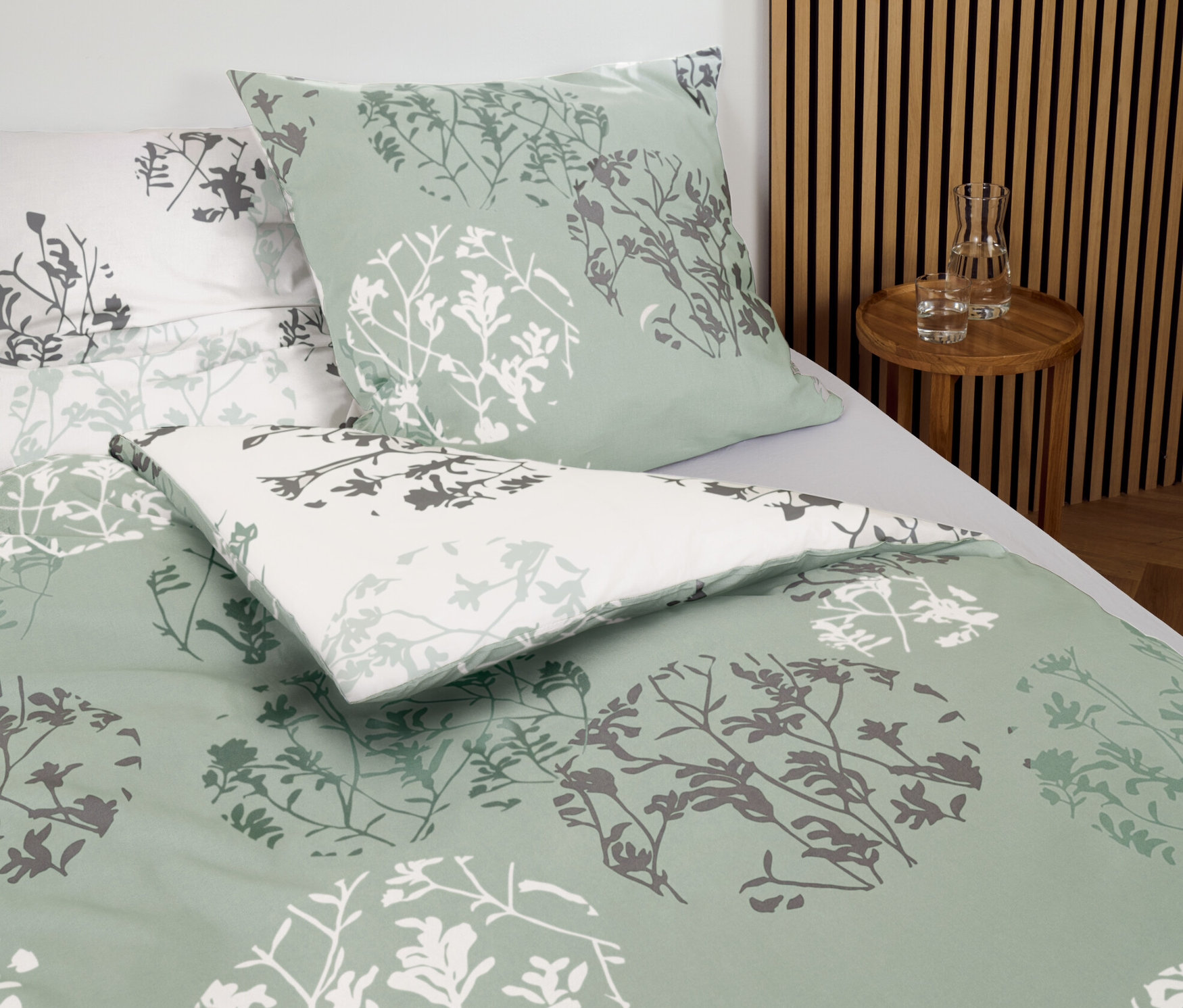 Közelkép a mentazöld, normál méretű és extra méretű, virágmintás renforcé ágyneműről.