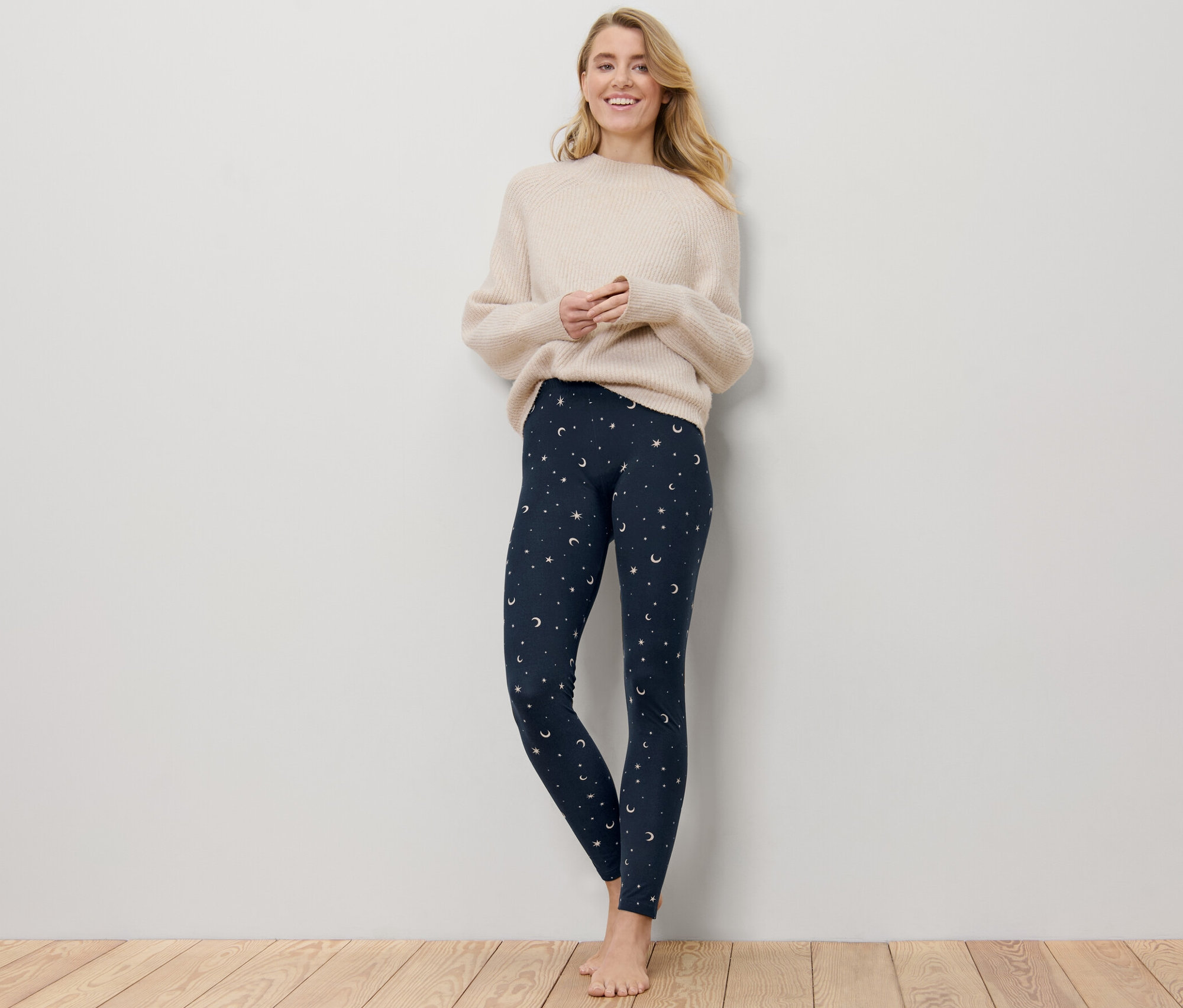 Nő áll, sötétkék csillagos női leggingset visel.