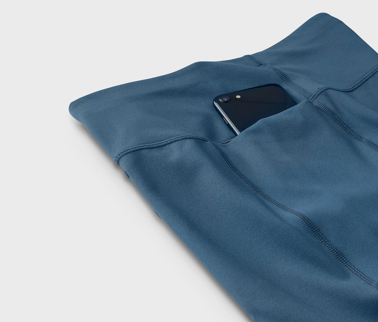 Kék leggings telefonnal a zsebben.