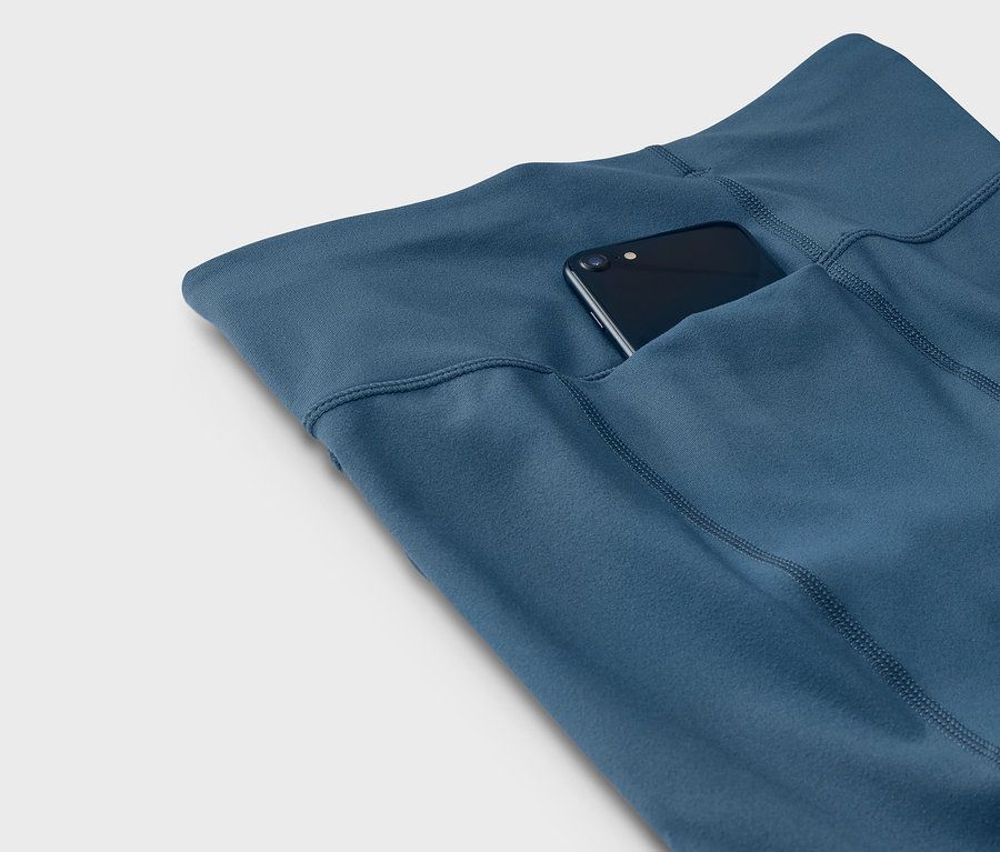 Kék leggings telefonnal a zsebben.