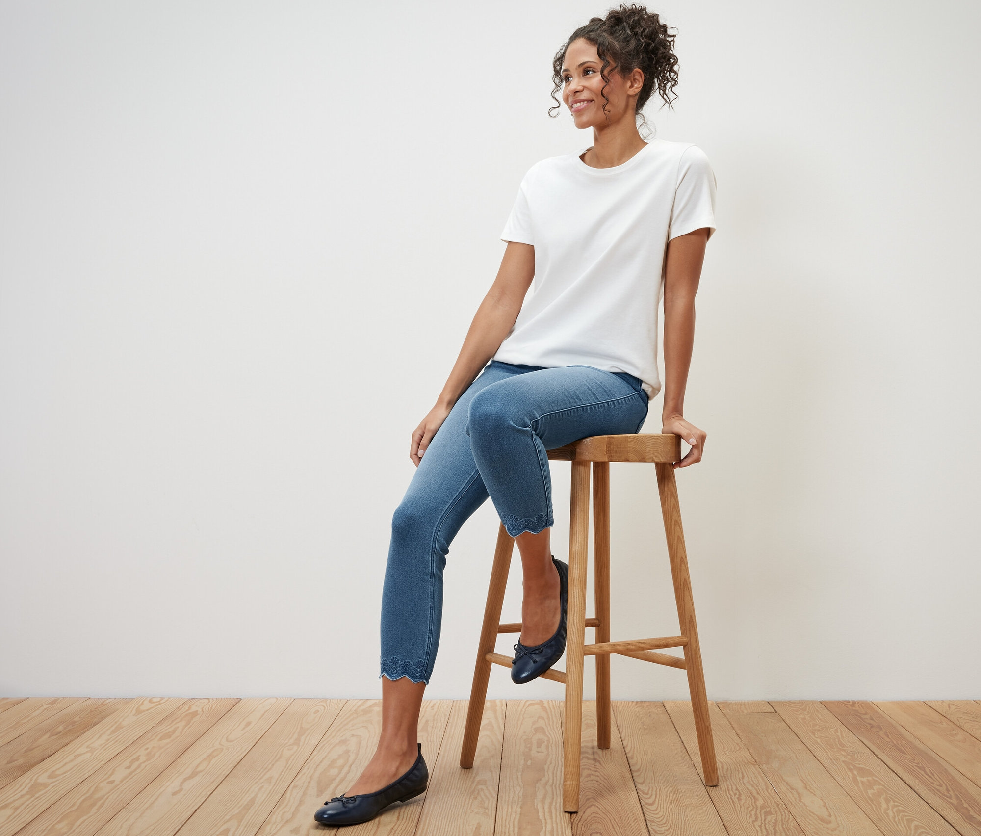 Nő ül egy széken, és 7/8-os, lyukhímzéses treggingst visel.