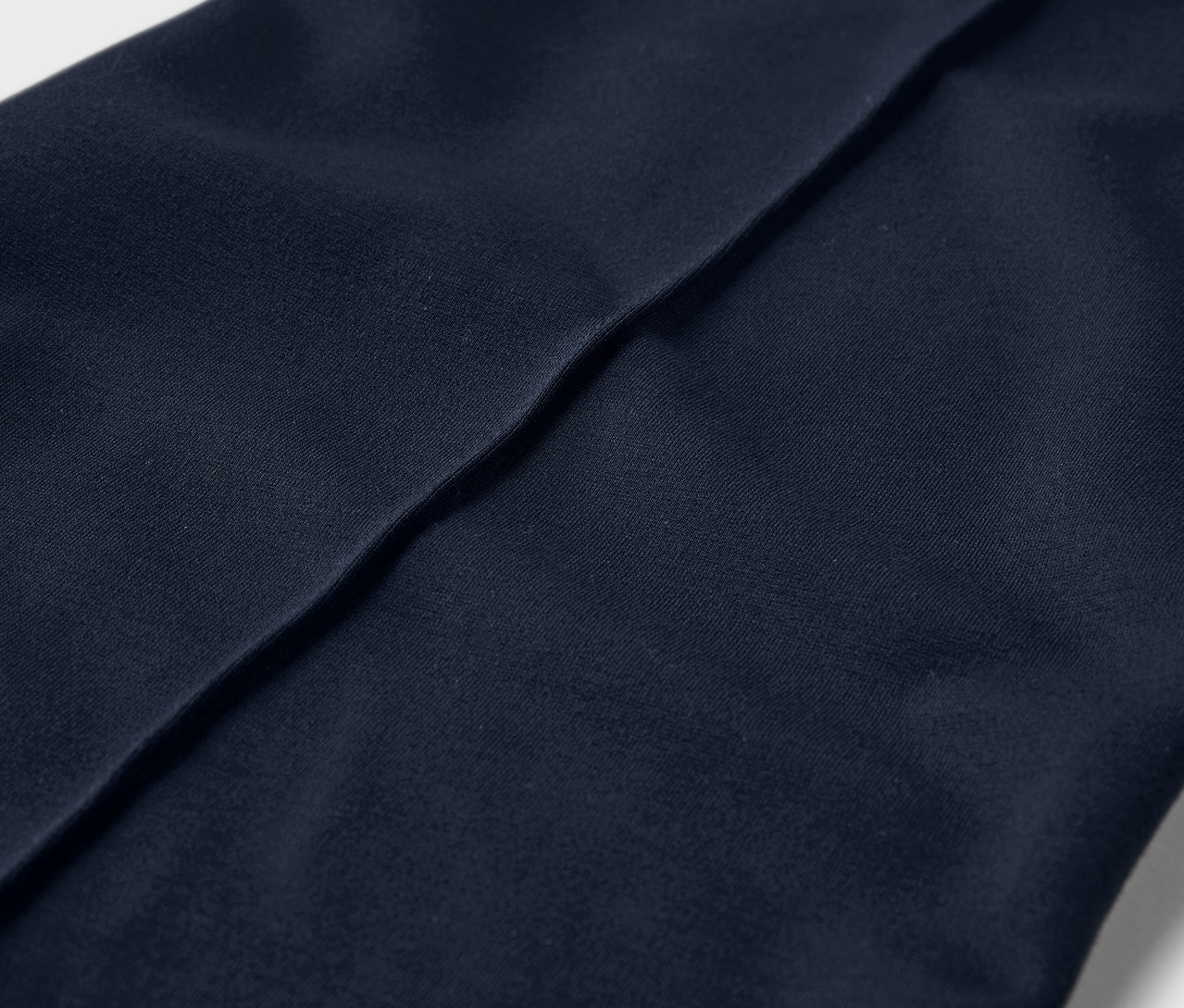 Egy levarrt éllel ellátott jersey nadrág részletének közeli képe.