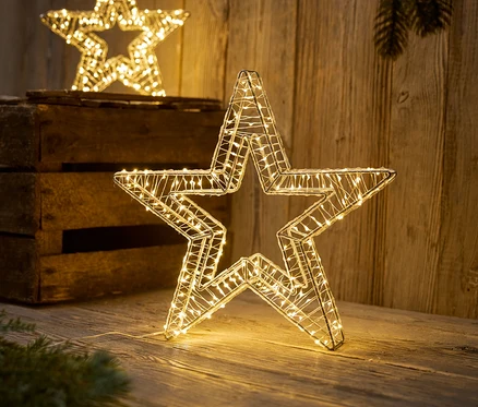 Két dekoratív csillag LED-es lámpákkal egy fa felületen áll.