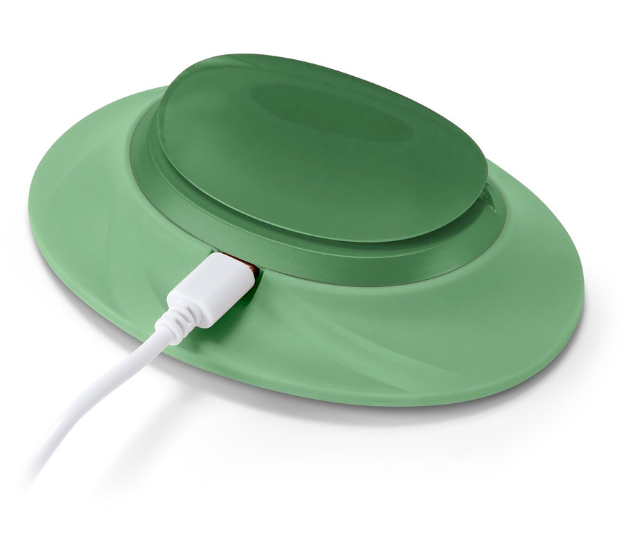 Zöld vezeték nélküli töltő csatlakoztatott fehér USB-C kábellel.