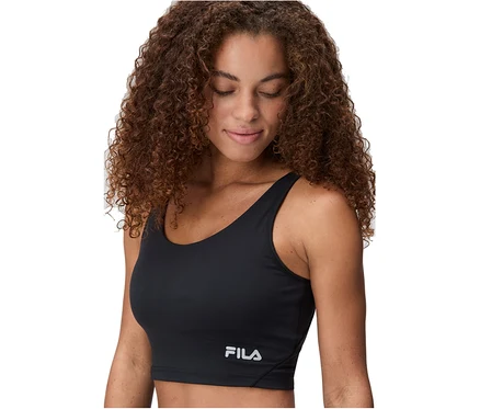 Göndör barna hajú nő fekete FILA női sport crop topot visel, lefelé néz.