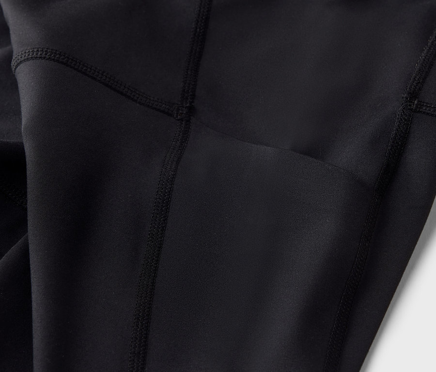 Közeli felvétel egy fekete leggingsről, zsebbel.