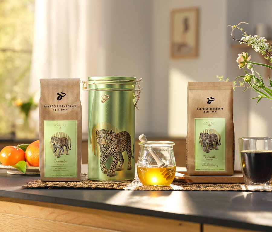 A konyhapulton egy kávésdoboz és két »Buramba Rwanda« csomag, köztük egy kávésdoboz áll egy csésze kávé és méz mellett.
