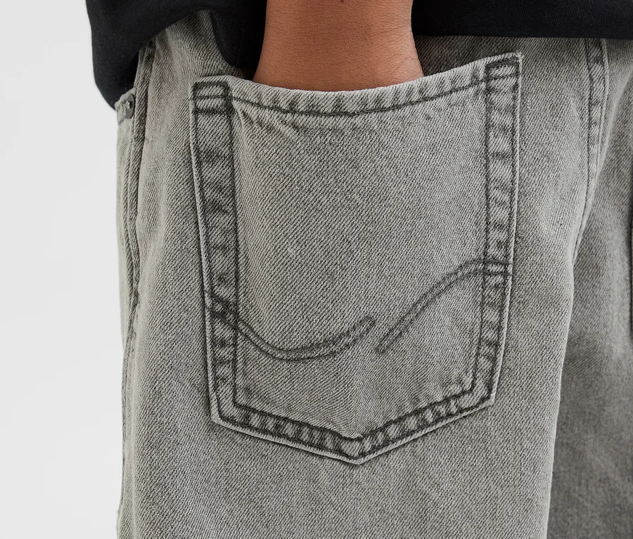 Kéz a szürke Jack&Jones JJOrginial Alex farmernadrág hátsó zsebében.