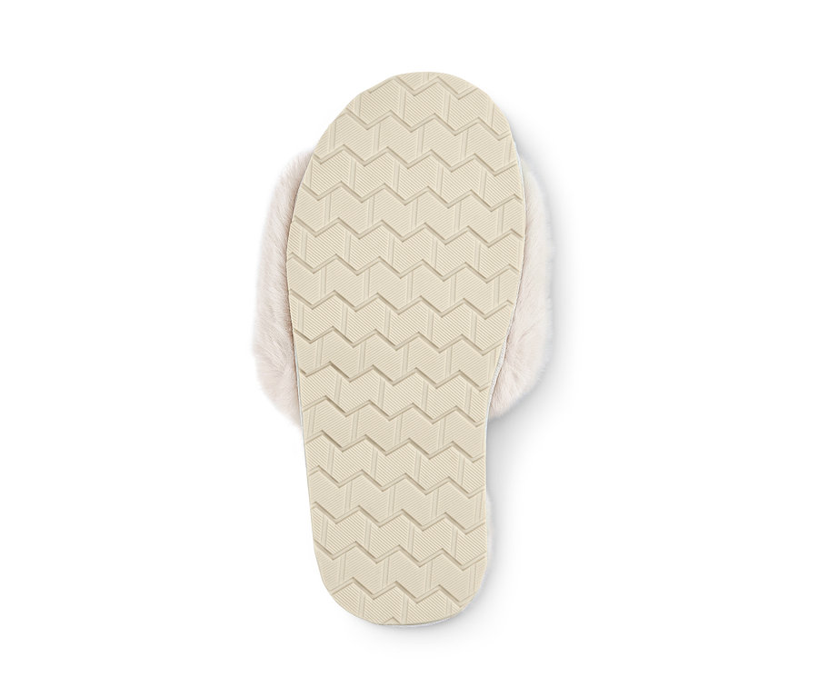 Egy krém színű, műszőrmés női papucs talpának részlete.