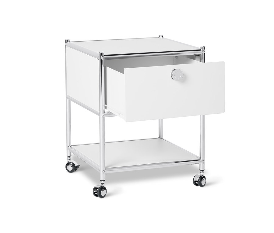 Egy fehér, fém éjjeliszekrény, görgős, 1 fiókkal; a fiókja nyitva.