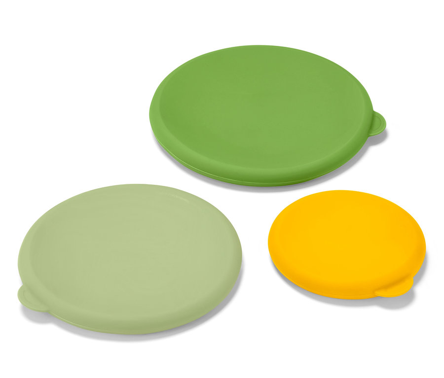 Három szilikon frissentartó fedő zöld, világoszöld és sárga színben, fehér felületen.