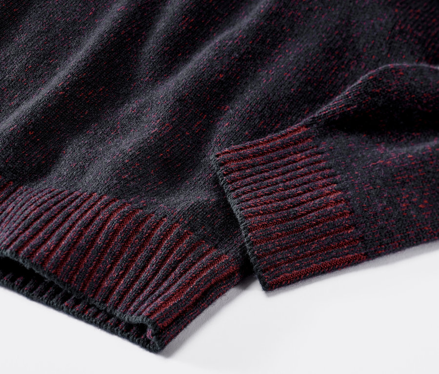 Sötétkék-piros, gyapjúval készült kötött pulóver részlete.