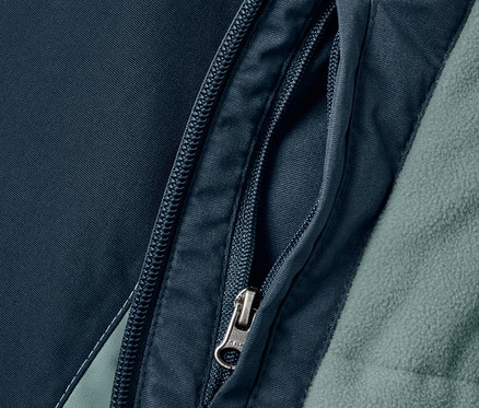 Egy sötétkék/zöld fiú snowboard kabát részlete, cipzáras zsebbel.