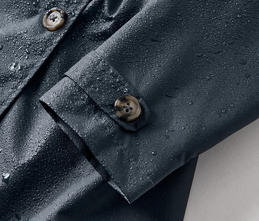 Egy sötétkék lány ballonkabát részlete, vízcseppekkel.