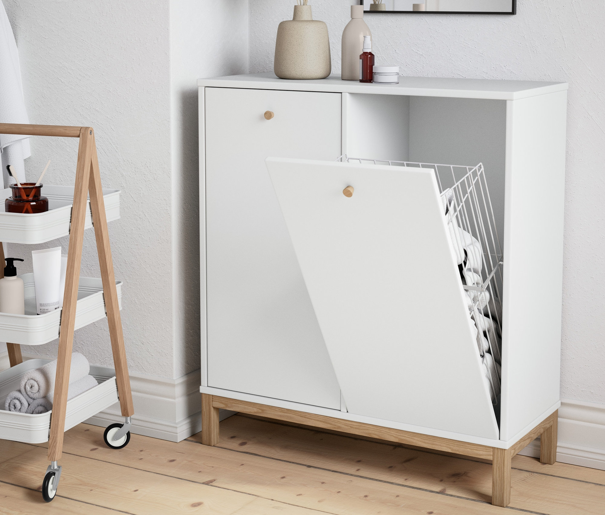 A fürdőszobában egy szennyestartó szekrény és egy gurulós fürdőszobai tároló látható.