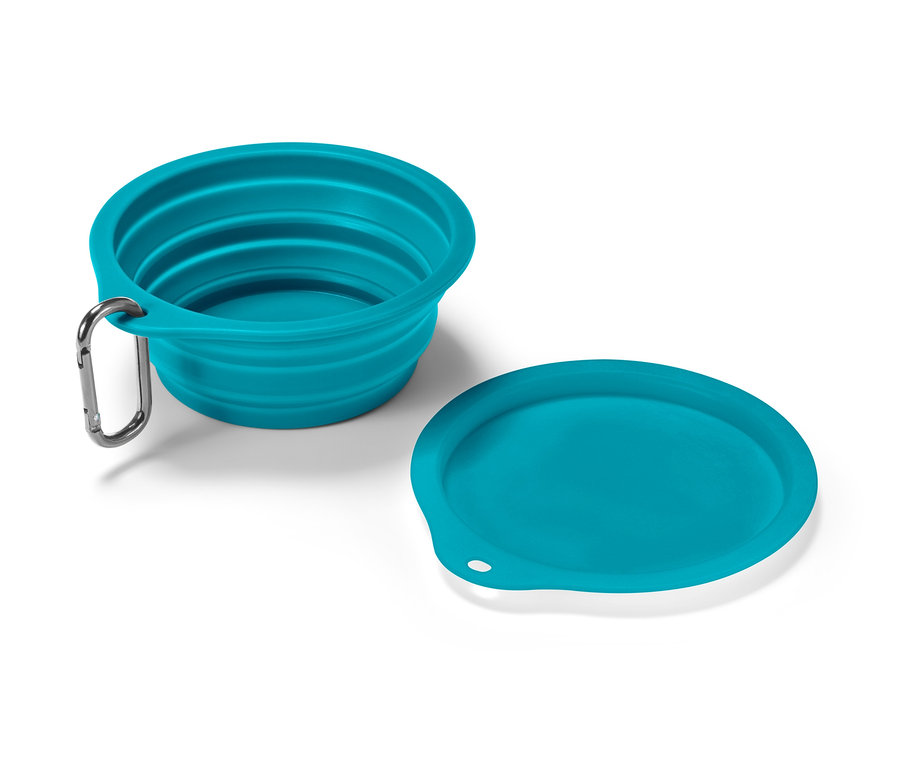 Egy türkiz összecsukható etetőtál és egy fedő fekszik egy fehér felületen.