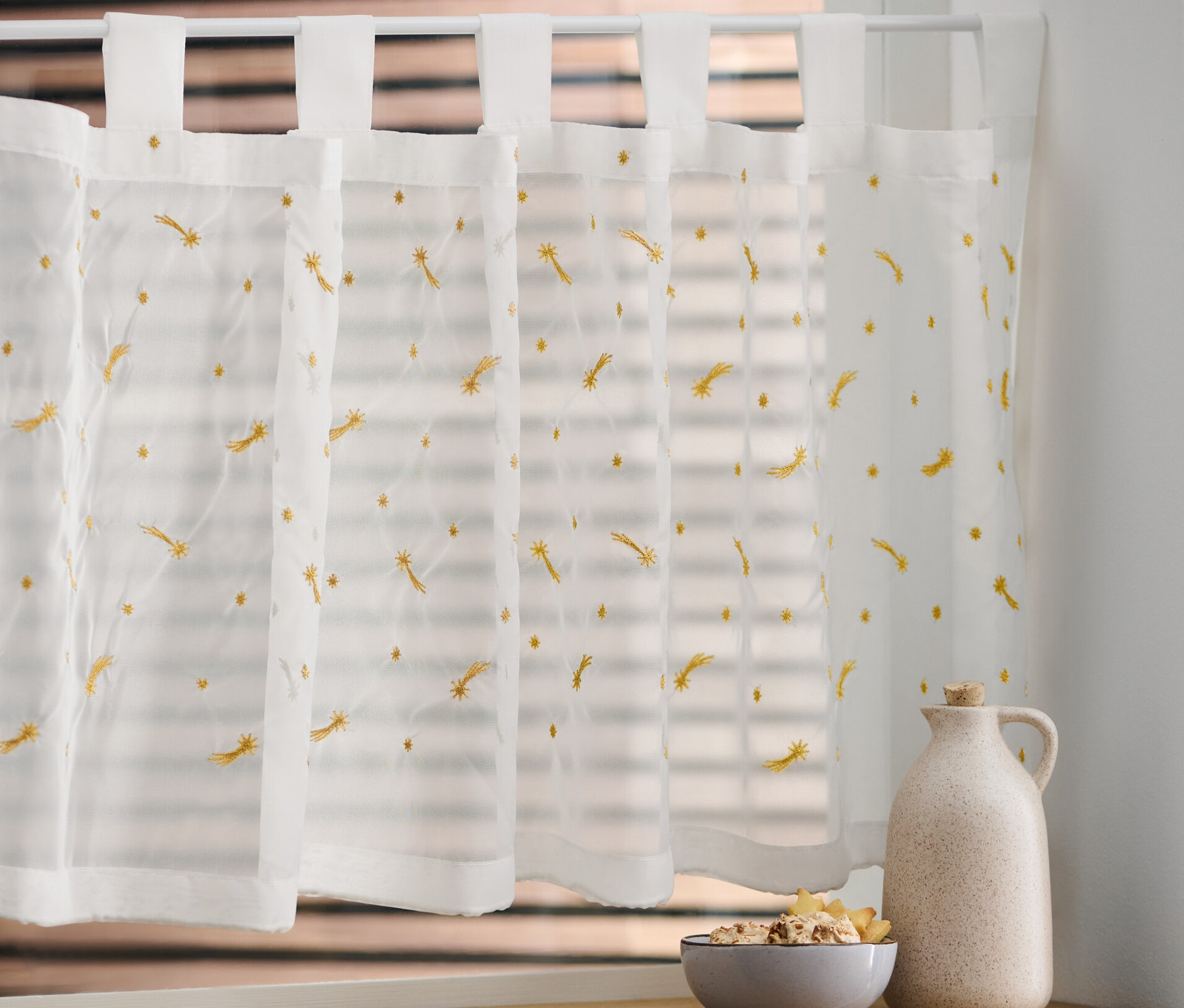 Hímzett vitrázsfüggöny az ablakon.