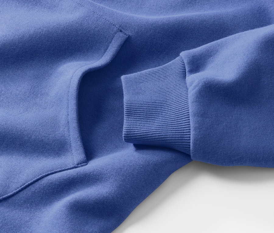 Egy kék, kapucnis női lezser ruha részlete zsebbel és bordázott ujjvéggel.